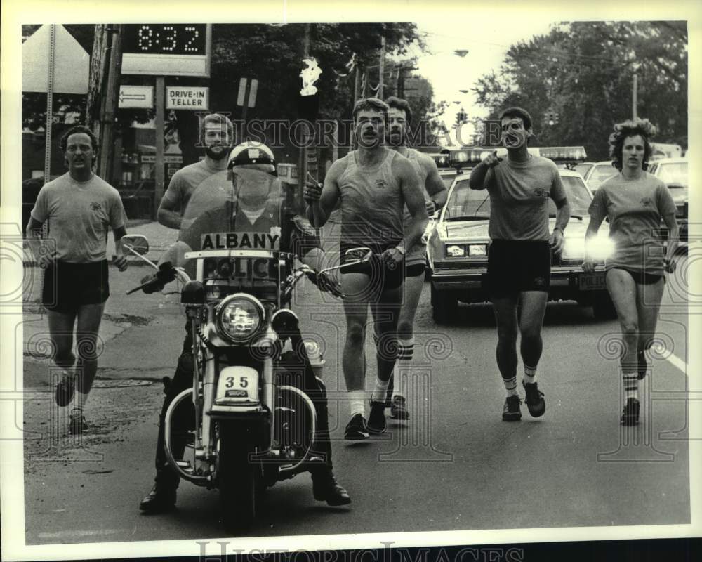 1984 Press Photo Albany, New York police escort torch bearer for Police Olympics