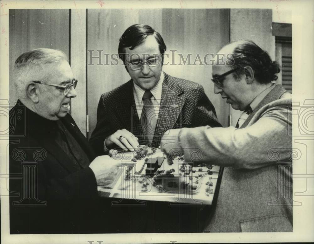 1976 Press Photo Officials study model of proposed housing unit in New York