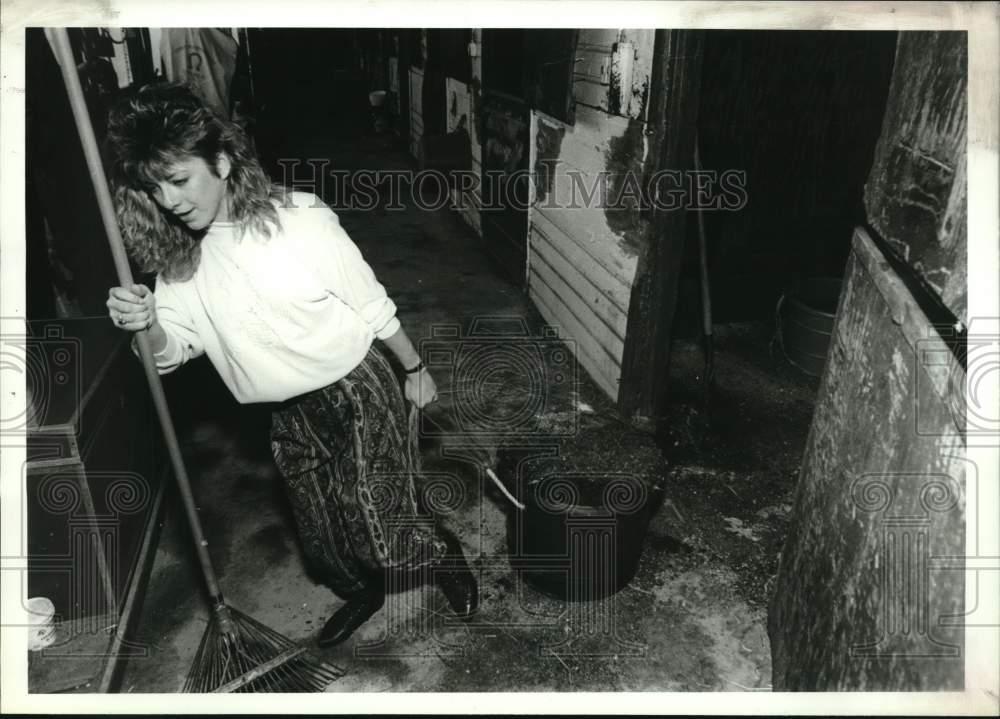 1990 Press Photo Kelly Clark cleans stables at Saratoga Harness Track, New York- Historic Images