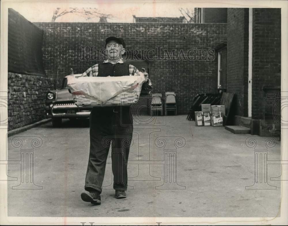 1961 Press Photo Frank Keller carries basket from mansion in New York