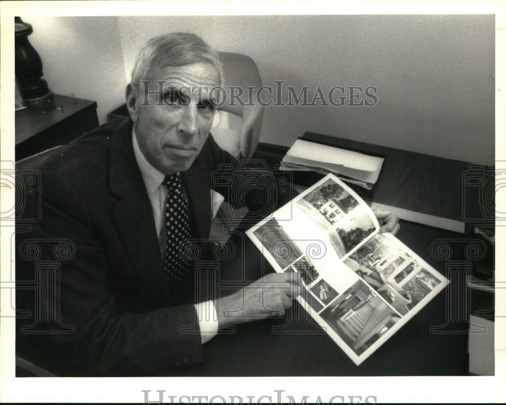 1989 Press Photo Irving Price with home sales brochure at office in New York
