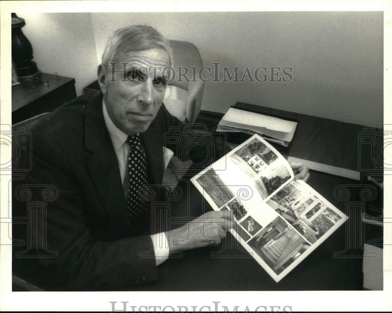 Load image into Gallery viewer, 1989 Press Photo Irving Price with home sales brochure at office in New York
