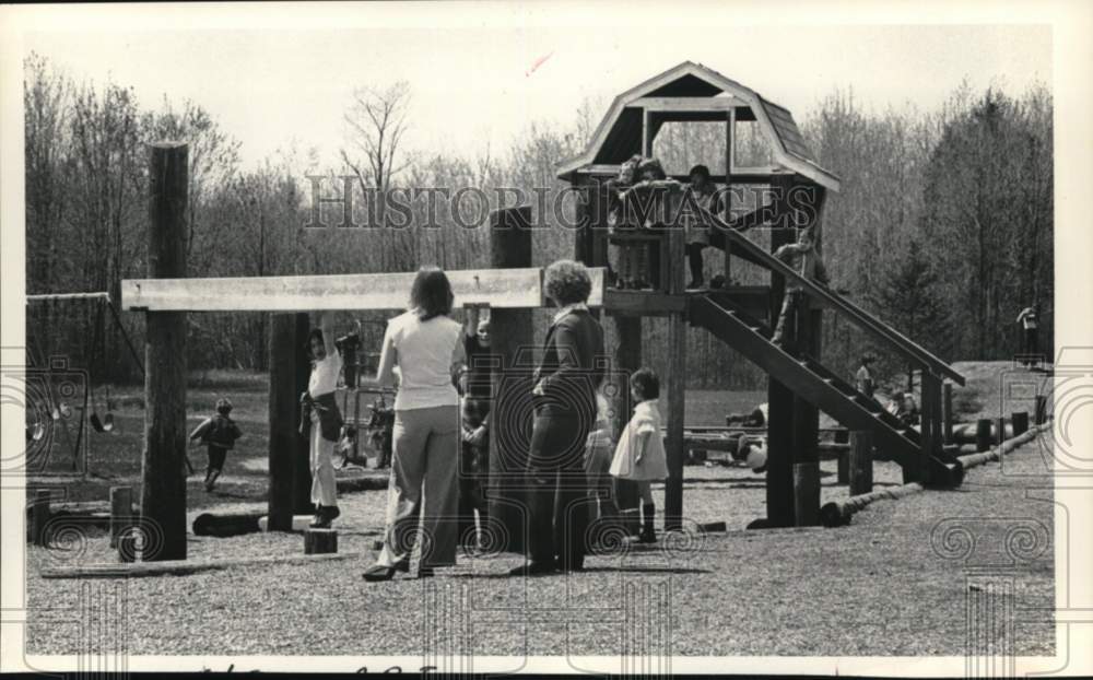 1978 Press Photo Parents watch kids on playground in West Sand Lake, New York- Historic Images