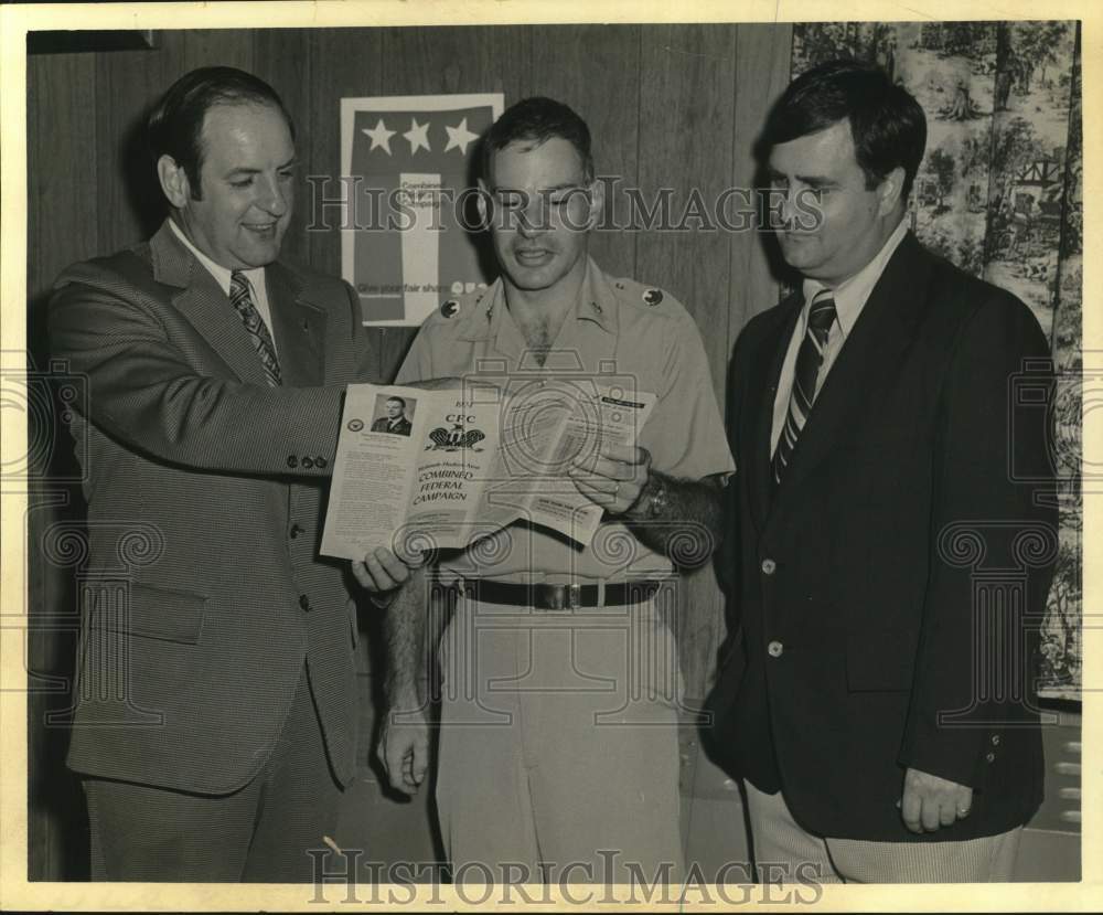1973 Press Photo Fred Elas, Richard Sawyer and Dave Coddington view brochure.