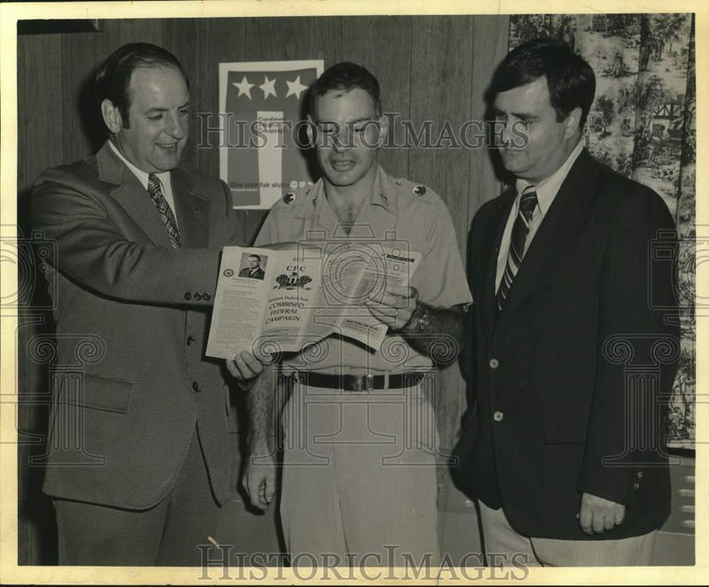 Load image into Gallery viewer, 1973 Press Photo Fred Elas, Richard Sawyer and Dave Coddington view brochure.

