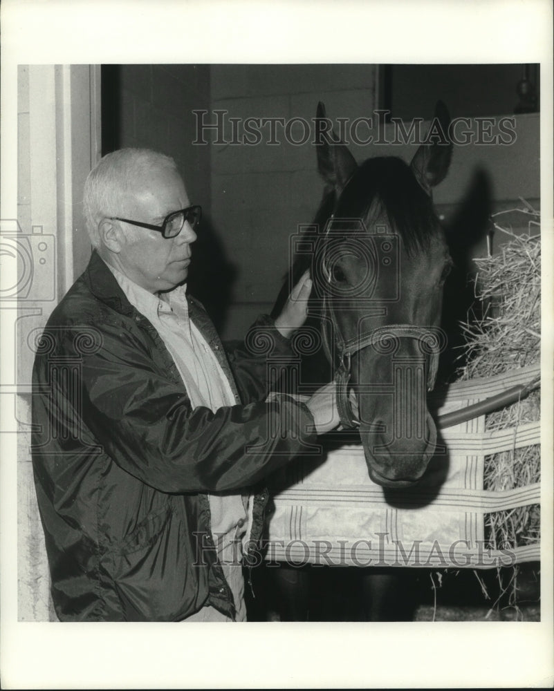 1980 Press Photo Phil Johnson pets race horse at Saratoga Raceway, New York- Historic Images