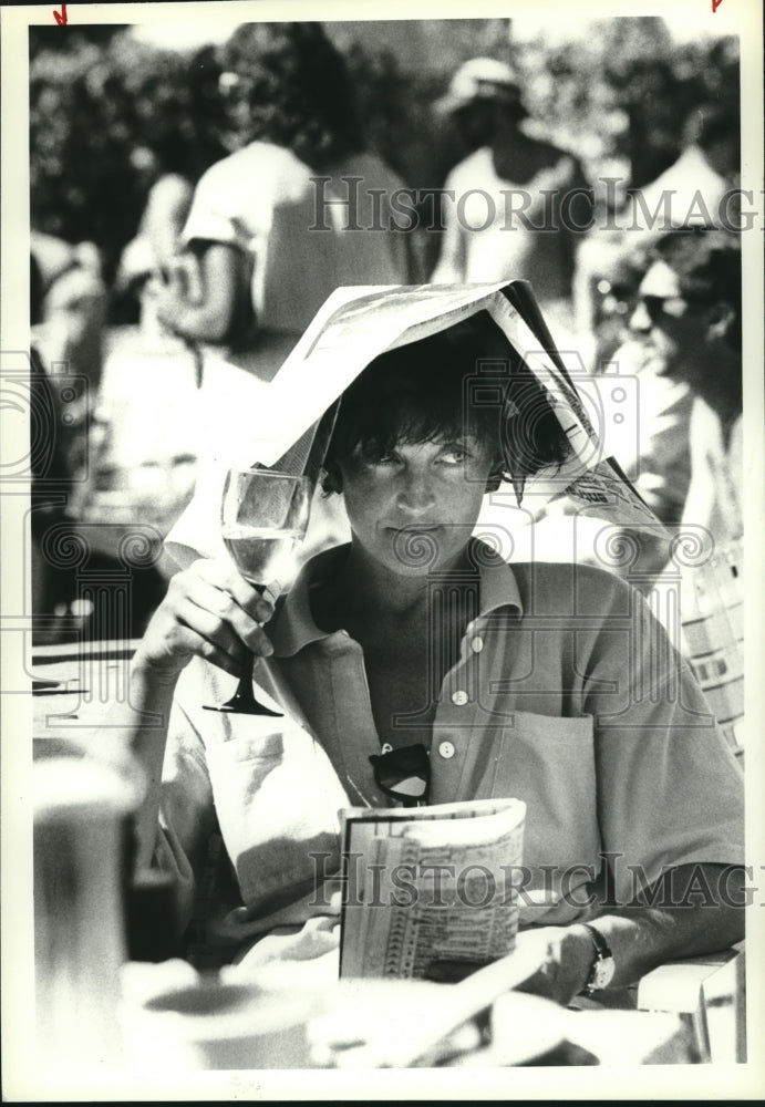 1988 Press Photo Joann Doyle watches race with program as hat and goblet of wine- Historic Images