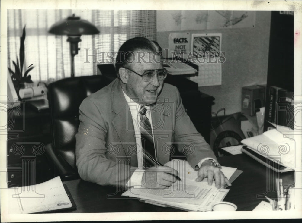 1984 Press Photo School superintendent Thomas Mitchell sits behind desk- Historic Images