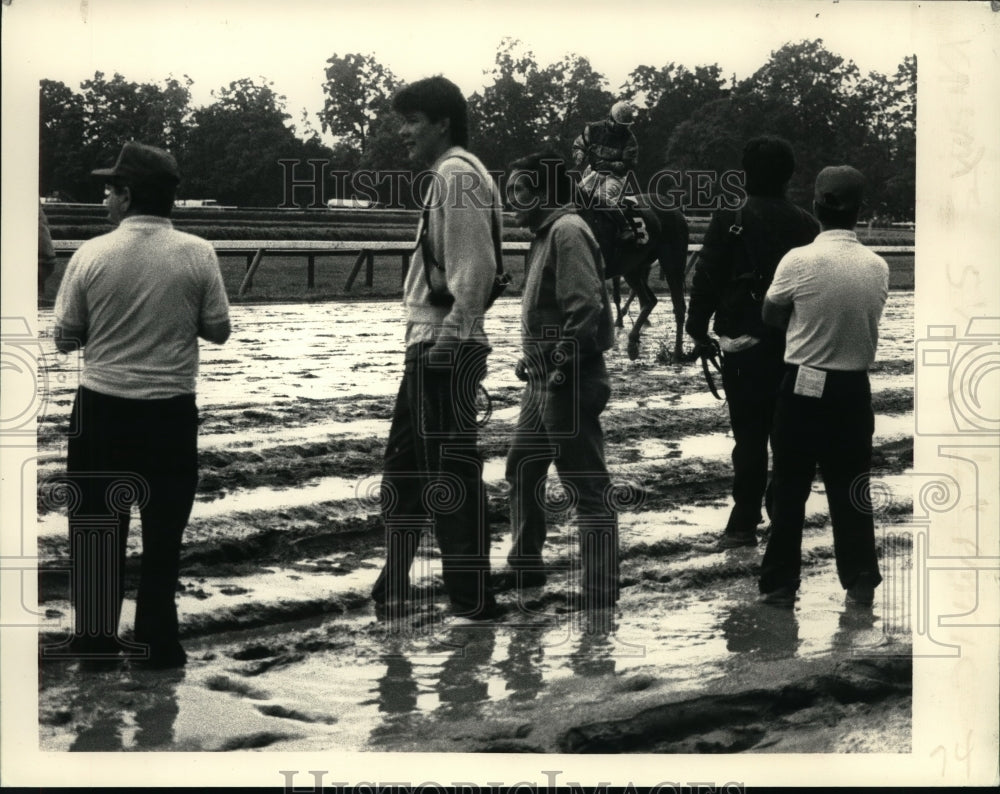 1987 Press Photo Horse handlers await return of horses on sloppy track- Historic Images