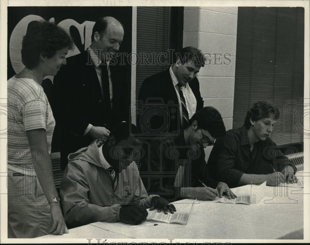 1984 Press Photo Coaches watch basketball players sign letters St Rose College- Historic Images