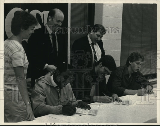 1984 Press Photo Coaches watch basketball players sign letters St Rose College- Historic Images
