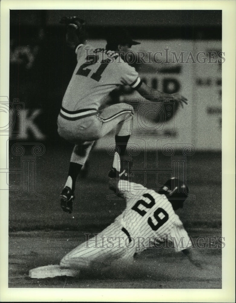 1989 Press Photo Harrisburgh #21 Carlos Garcia leaps over a sliding Yank in game- Historic Images