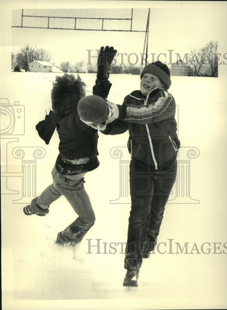 1986 Press Photo Kids play football in the snow in Latham, New York - tus01749- Historic Images