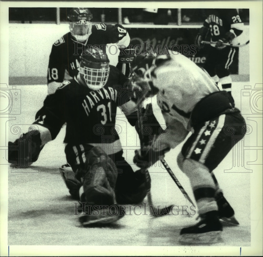 1988 Press Photo RPI hockey player #15 Denis Poissant slaps puck thru legs- Historic Images