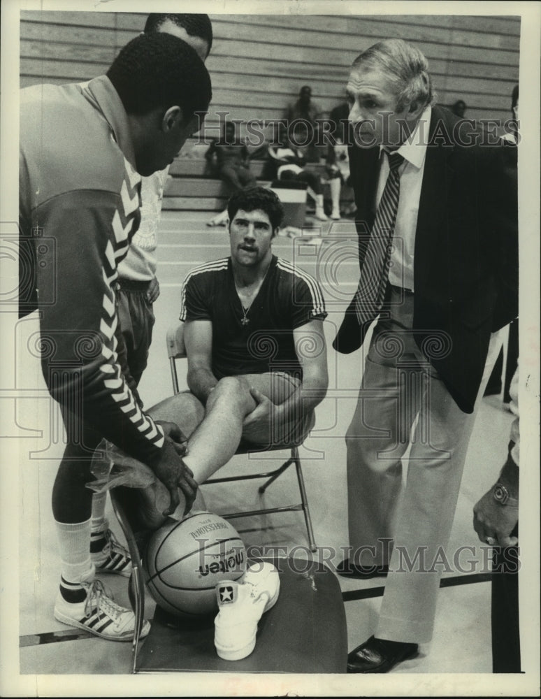 1982 Press Photo Hollis Copeland applies ice pack to ankle of basketball player- Historic Images