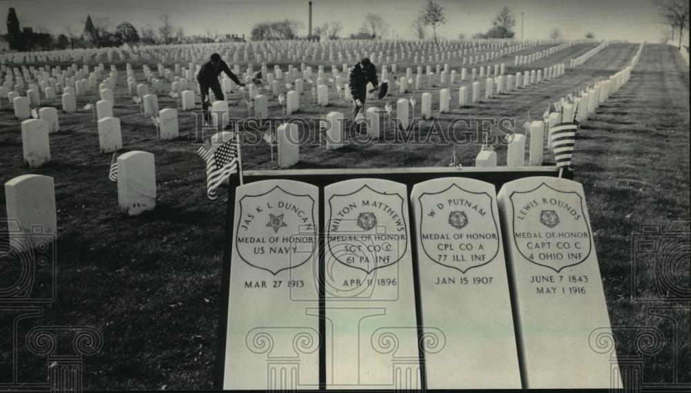 1984 Press Photo Veterans placing flags on graves at Wood National Cemetery - Historic Images