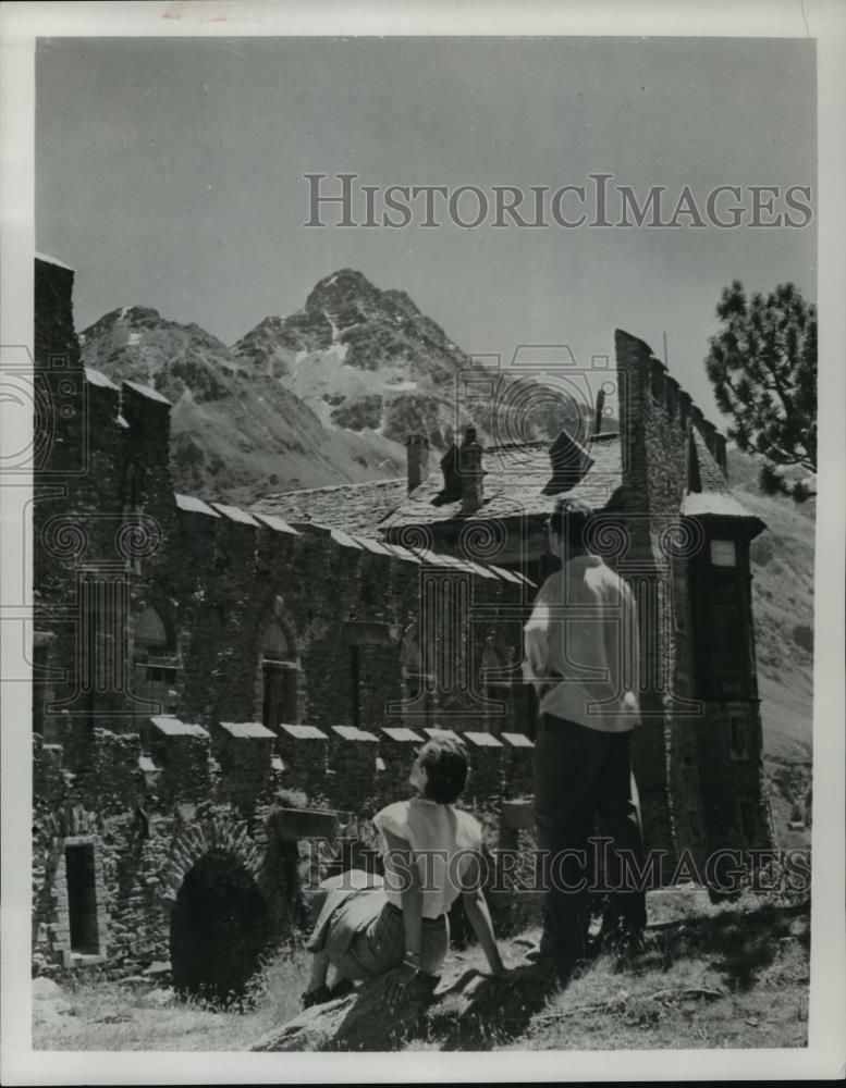 Press Photo Man and woman admire an old home on the side of a mountain - Historic Images