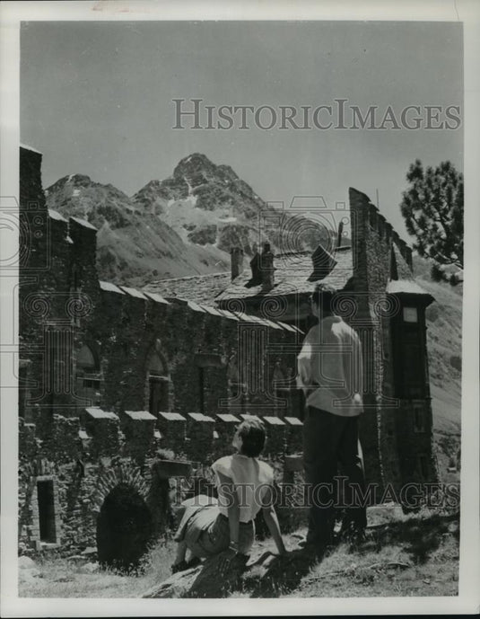 Press Photo Man and woman admire an old home on the side of a mountain - Historic Images