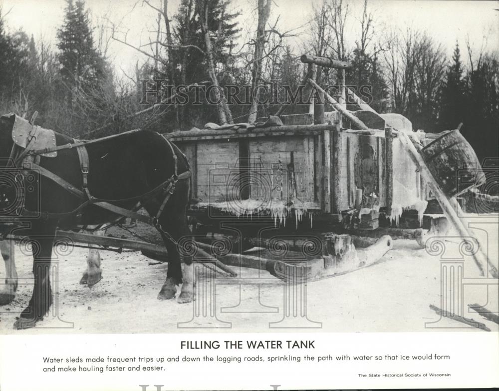 1982 Press Photo Water sleds sprinkle logging roads to make ice for easier hauls - Historic Images