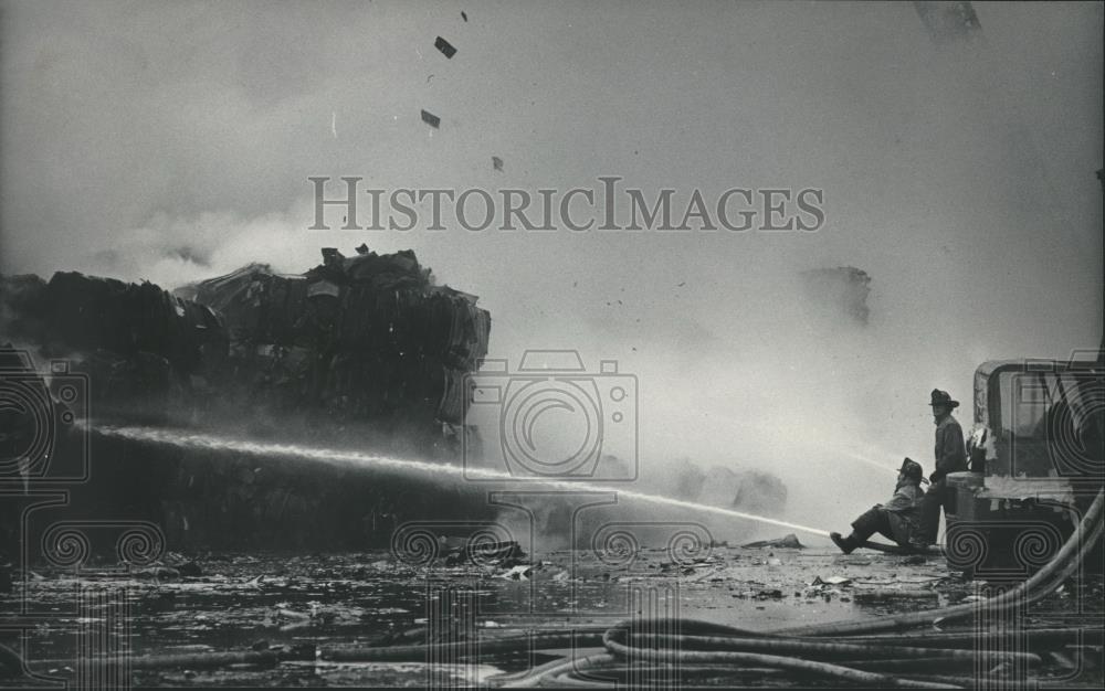 1984 Press Photo Firefighters hose down mounds of paper at plant, Milwaukee. - Historic Images