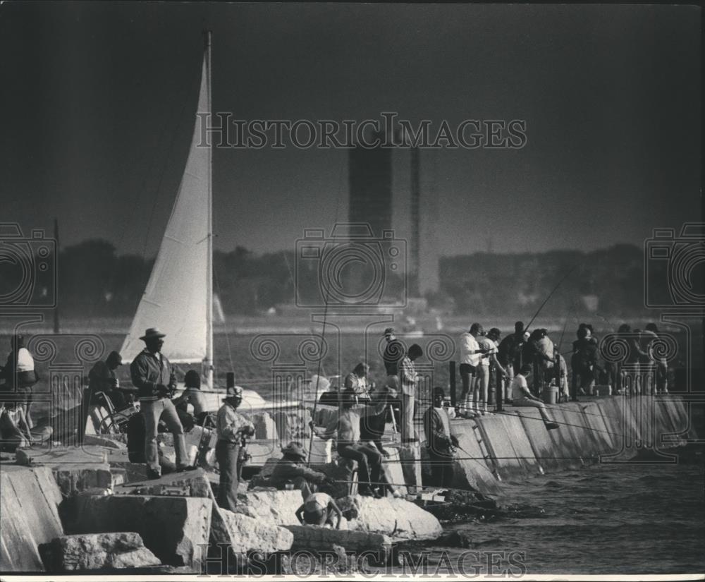 1984 Press Photo Fishermen crowd breakwater near the Milwaukee Yacht Club. - Historic Images