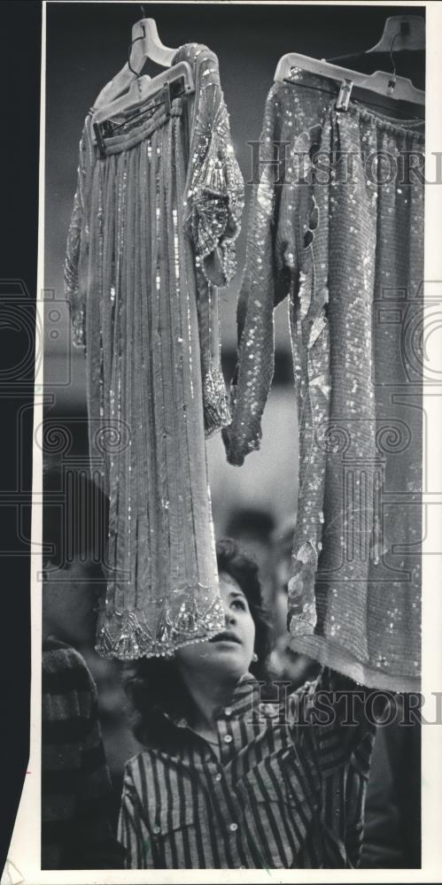 1985 Press Photo Sara Joel, looks at Pakistani dresses at the Folk Fair. - Historic Images