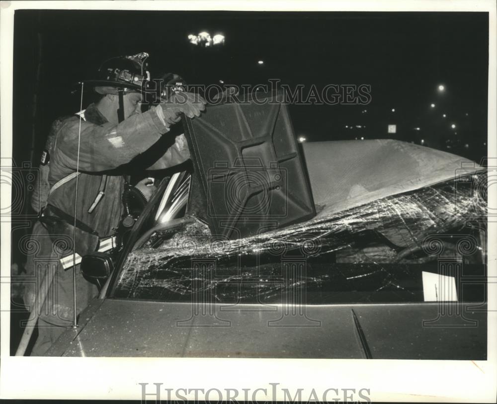 1991 Press Photo Manhole cover drops onto car after explosion, Milwaukee. - Historic Images