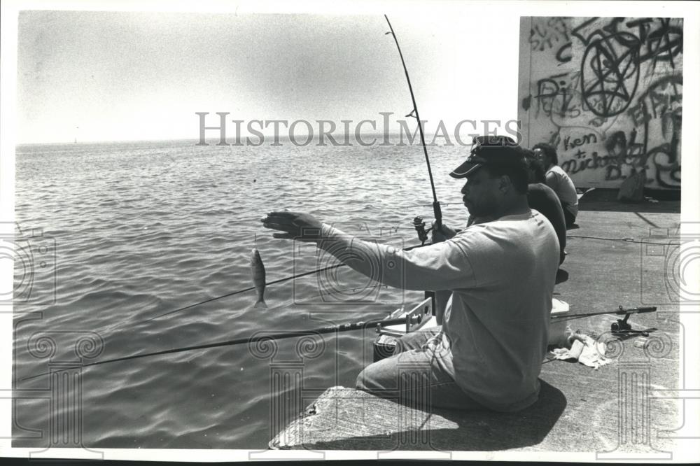 1991 Press Photo Fisherman Vernell Patton catches Perch at McKinley Breakwater - Historic Images