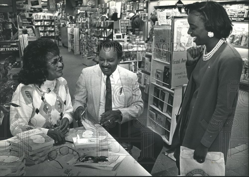 1992 Press Photo Johnnie M. and Jim Foote sign a book for a customer, Milwaukee. - Historic Images