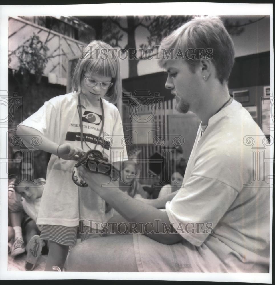 1994 Press Photo Maureen Fay pets a 3-foot python as Dan Riedel advises - Historic Images