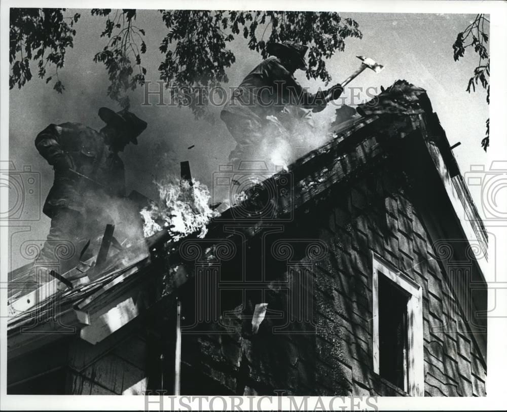 1990 Press Photo Firefighters battle a blaze on the roof of a Milwaukee building - Historic Images