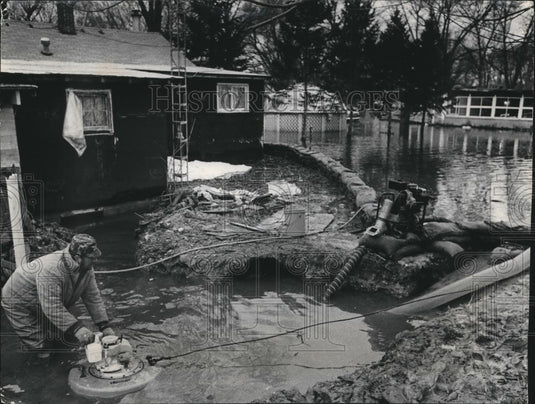 1979 Press Photo Darrell Prisk pumps flooding water from his home, Wisconsin. - Historic Images