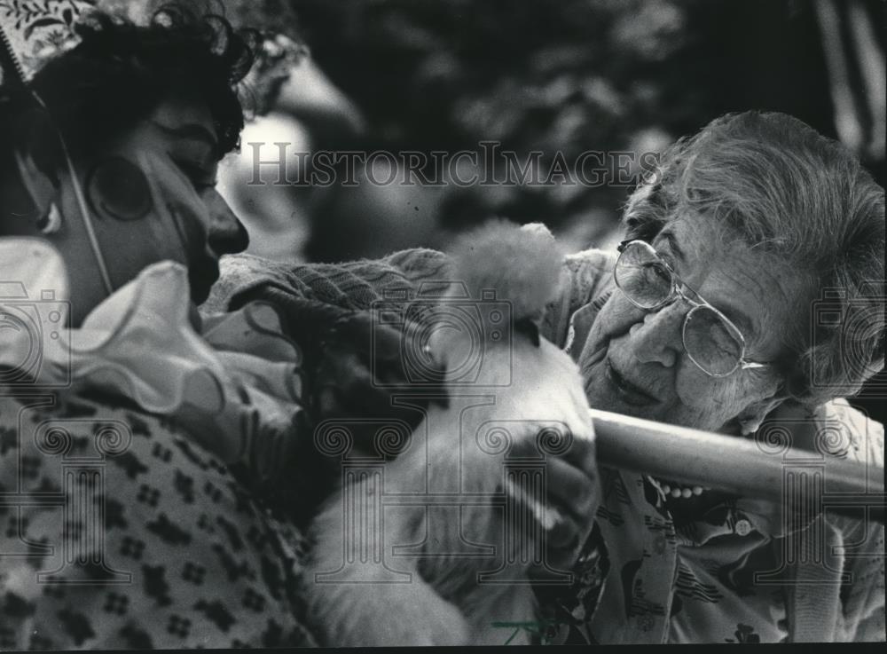 1984 Press Photo Norma Wollf of Luther Manor with Clown holding Chicken at Event - Historic Images