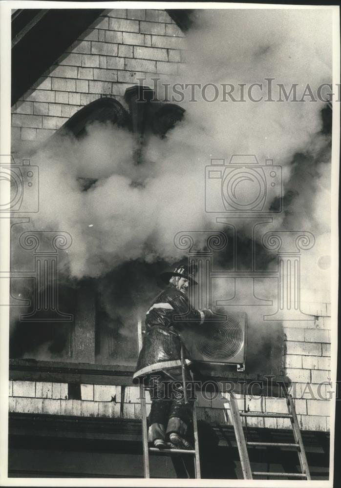 1990 Press Photo Firefighter Battles Attic Fire In Milwaukee, Wisconsin - Historic Images