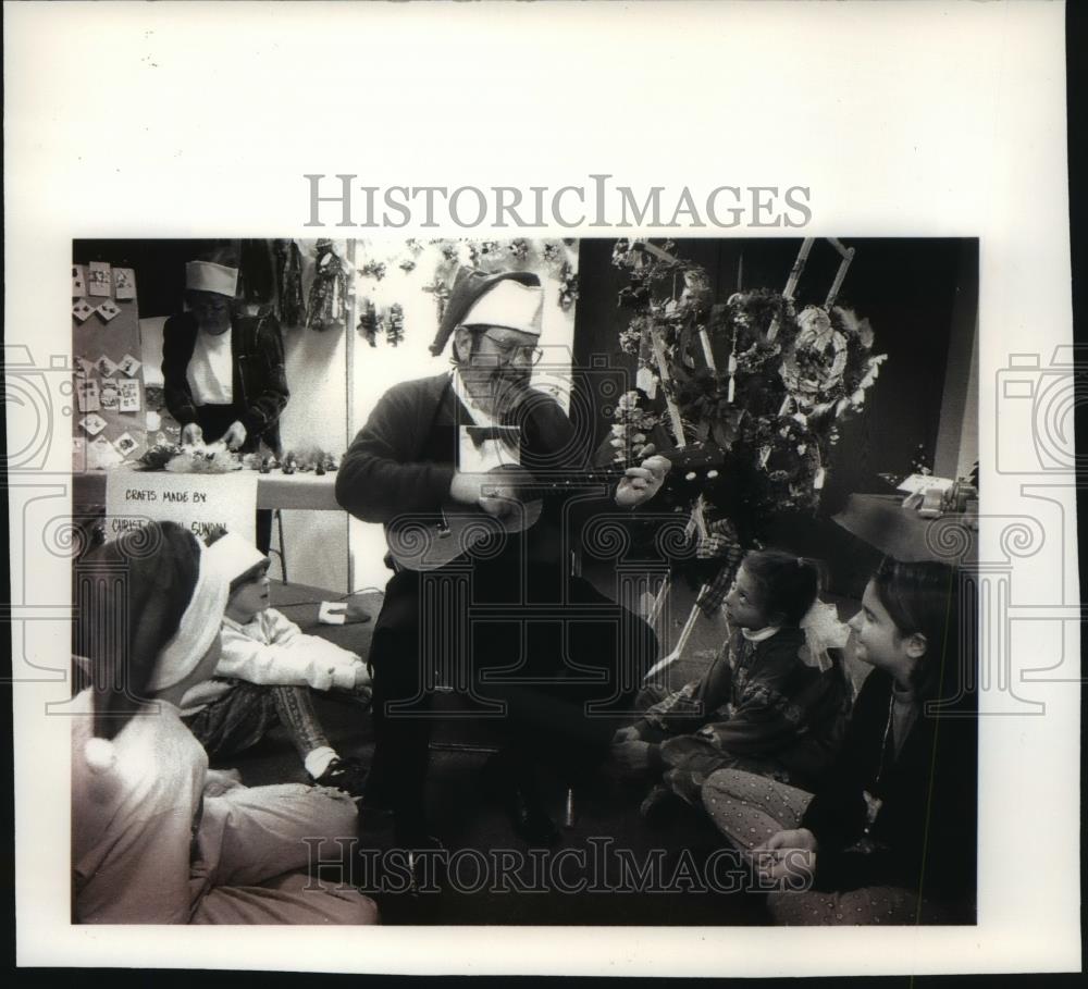1992 Press Photo In Santa Cap, Reverend Ellsworth E. Freyer Plays Uke for Kids - Historic Images