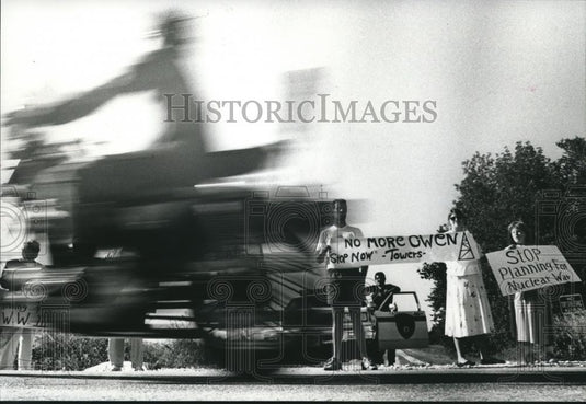1989 Press Photo A motorcyclist drives by protesters during a rally in Mequon. - Historic Images