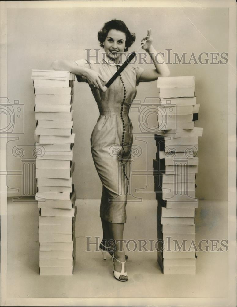 1955 Press Photo Model Stands In Between The Stacks Of Film - nef69346 - Historic Images