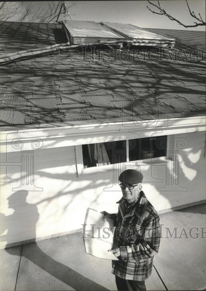 1979 Press Photo Mel Mueller looking at solar roof collectors, Germantown - Historic Images