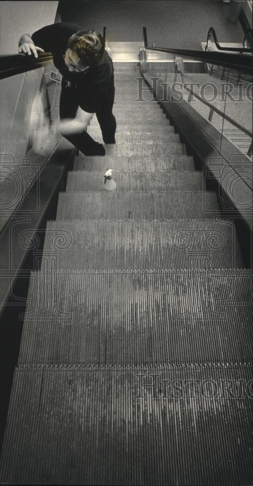 1987 Press Photo Tom Piontek cleaning escalators at the Mitchell Airport - Historic Images