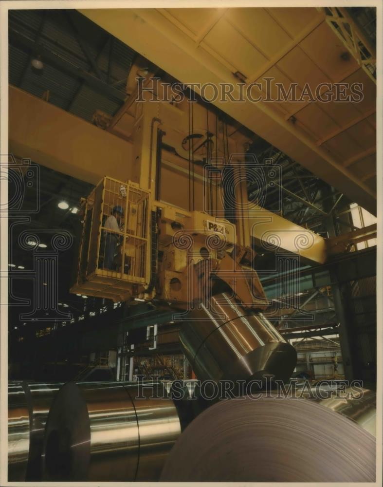 Press Photo Coil-handling crane moves rolls of aluminum for Reynolds Aluminum - Historic Images