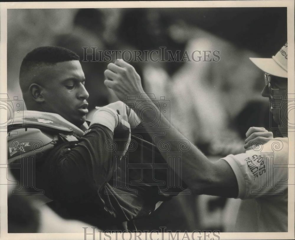 1989 Press Photo Alabama football player Derrick Ruston gets help with equipment - Historic Images