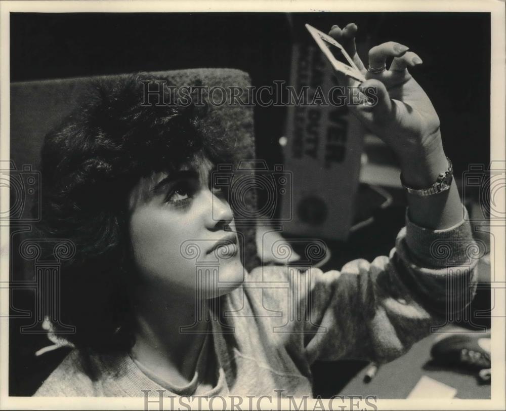1986 Press Photo Sylvia Fonte, looking at slides used in Spirit of Milwaukee. - Historic Images