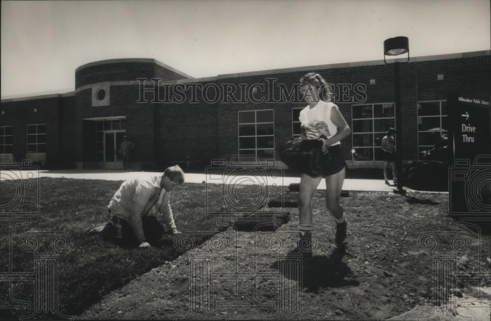 1989 Press Photo Workers lay sod for Center Street Library in Milwaukee. - Historic Images