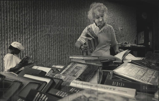 1983 Press Photo woman looks at books at Milwaukee Public Library book sale - Historic Images