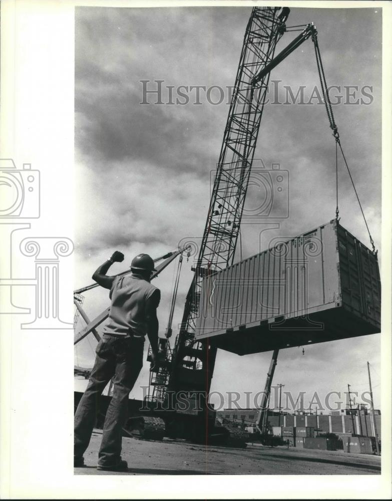 1983 Press Photo Wilburn Cunningham directs a crane operator at a Milwaukee dock - Historic Images