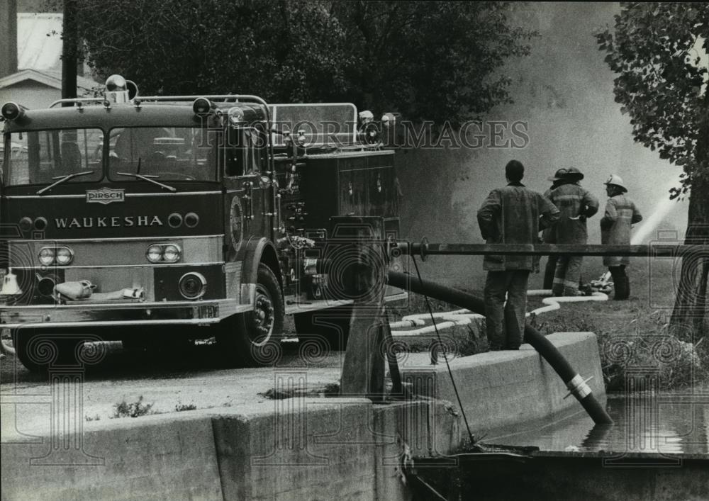 1981 Press Photo Waukesha, WI firefighters testing pump at the Fox River East. - Historic Images