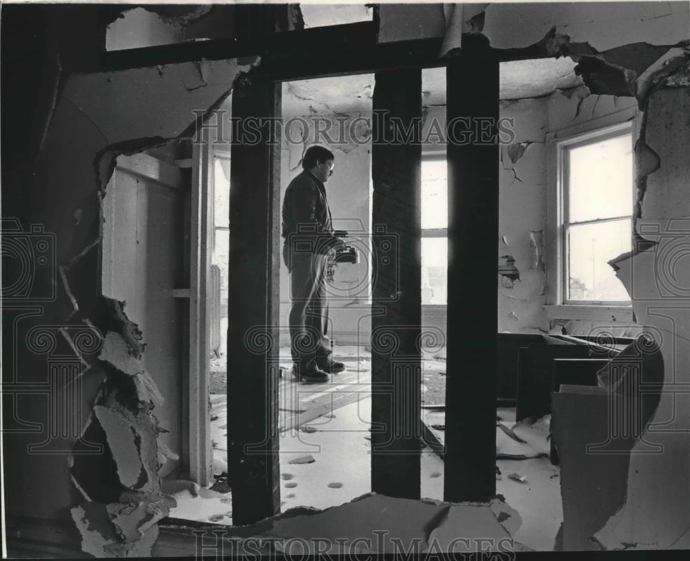 1985 Press Photo David Gardner inspecting damage of a abandoned home, Milwaukee. - Historic Images