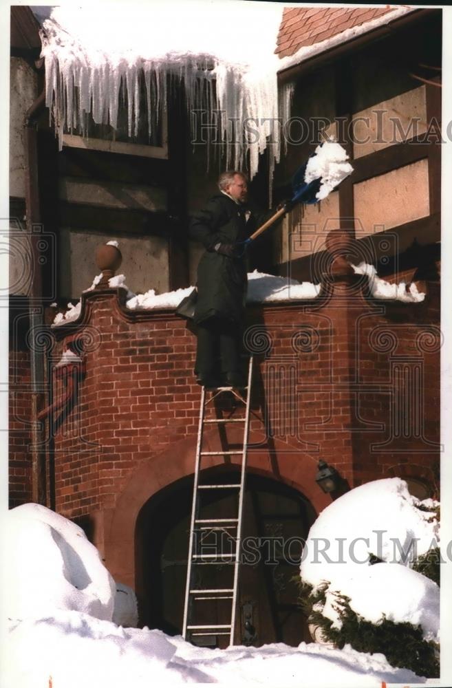 1994 Press Photo Bruce Johnson shovels snow from a leaking roof, Milwaukee. - Historic Images