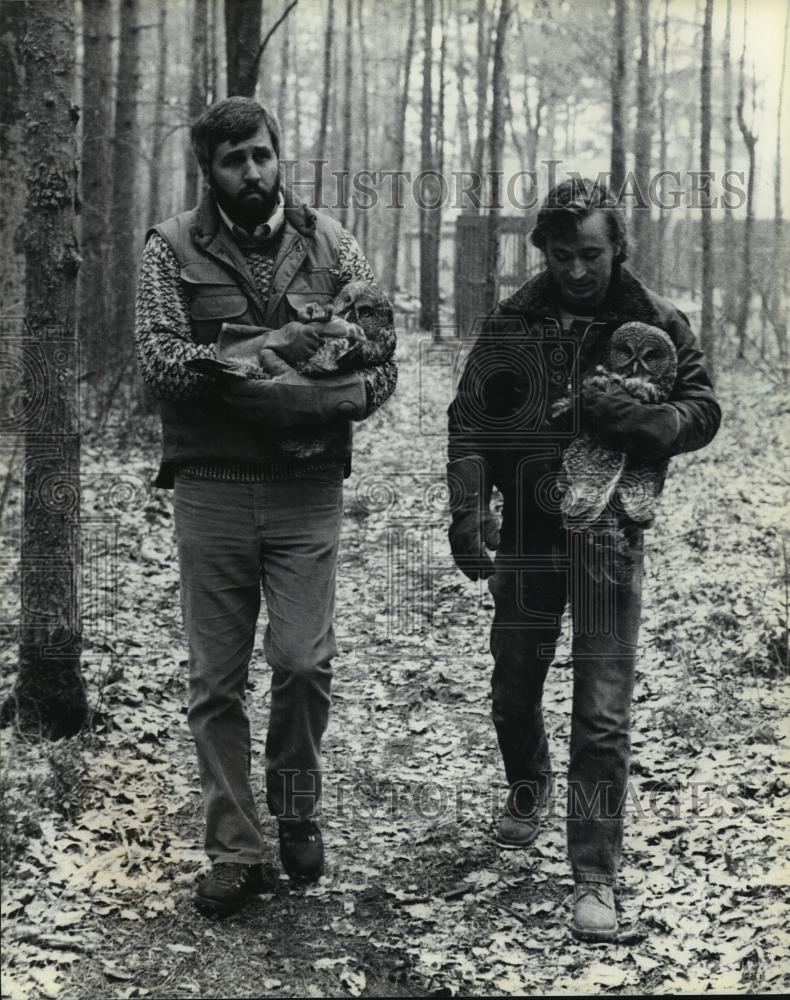 1984 Press Photo Mark Blackbourn, Dave Debauche, releasing owls to home in pines - Historic Images