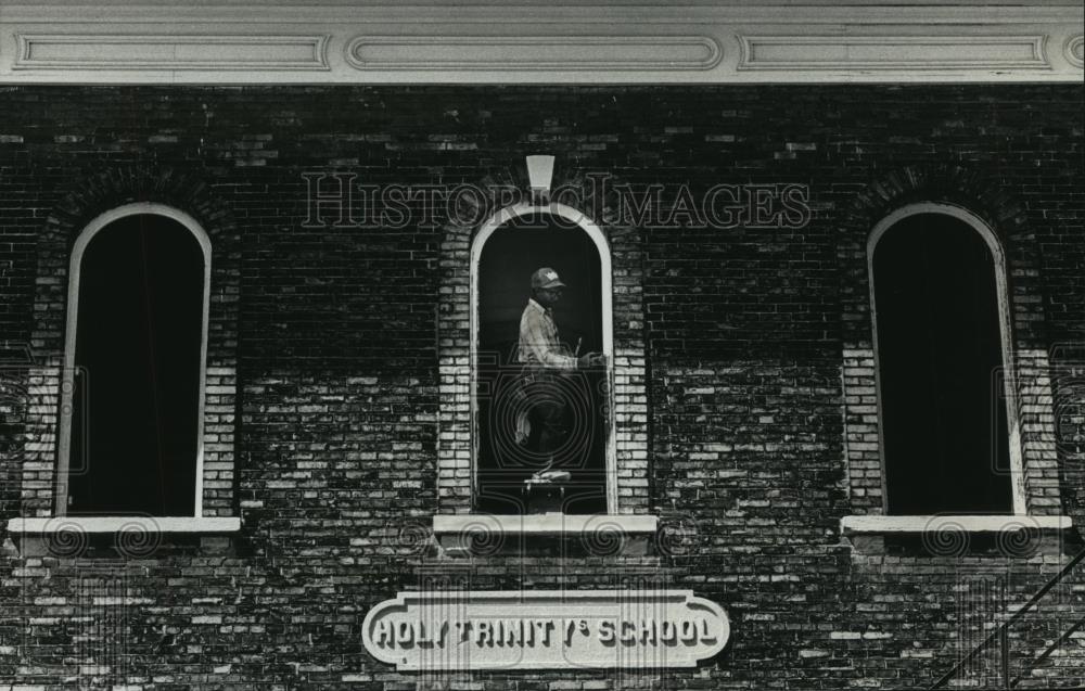 1992 Press Photo Gary Frazier scrapes paint at Holy Trinity school - Milwaukee - Historic Images